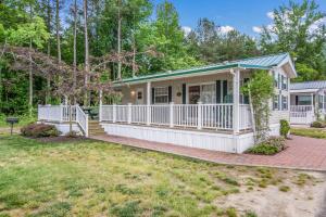 a white house with a porch and a fence at Bethpage Hewick Three-Bedroom Cottage 30 in Urbanna