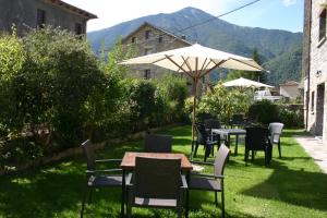 d'une terrasse avec des tables, des chaises et un parasol. dans l'établissement Casa Gallán, à Sarvisé