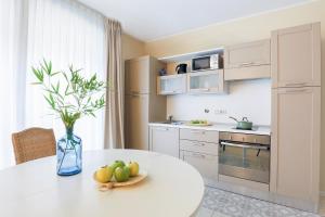 una cocina con una mesa y un jarrón con fruta. en Adriano Residence, en Bolonia