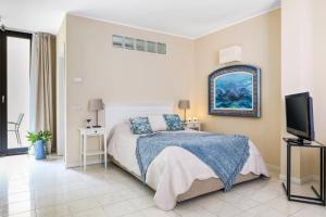 Un dormitorio con una cama y un televisor de pantalla plana. en Adriano Residence, en Bolonia