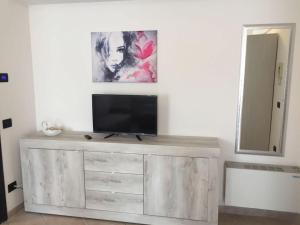 a television on top of a wooden dresser in a room at Residenza Meeting in Verona