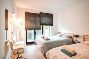 a bedroom with two beds and a chair and a window at Apartment Light House. Heart of Antwerp in Antwerp