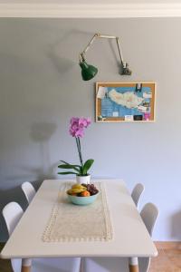 a white table with a bowl of fruit and a flower on it at Atlantis Flat. Relaxing Moments in Machico
