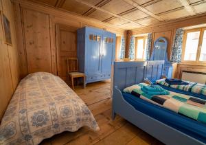 Schlafzimmer mit blauen Schränken und einem Bett in einem Zimmer in der Unterkunft Chasa Werro in Sent