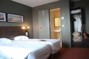 a hotel room with two beds and a bathroom at Orly Superior Hotel in Athis-Mons