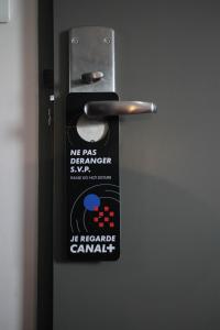 uma maçaneta de metal com um autocolante em Orly Superior Hotel em Athis-Mons