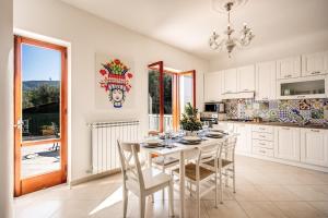 uma cozinha com uma mesa e cadeiras numa cozinha em MEDITERRANEAN HOUSE em Sorrento