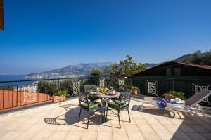 een terras met een tafel en stoelen op een balkon bij MEDITERRANEAN HOUSE in Sorrento