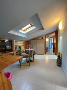 a living room with a dining room table and a skylight at Albergo La Pineta in Marina di Andora