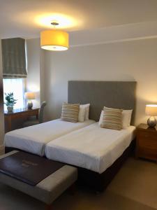 a hotel room with two beds and a lamp at Inverness City Suites in Inverness