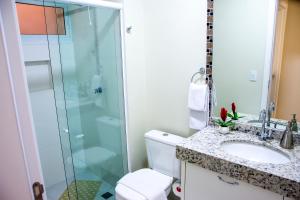 a bathroom with a shower and a toilet and a sink at APTO ACONCHEGANTE proximo ao centro in Foz do Iguaçu +24 photos