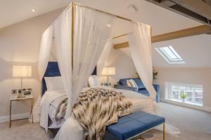 a bedroom with a canopy bed with white curtains at Heritage Mews Nottingham in Nottingham