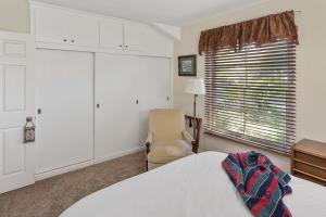 グレンデールにあるOak Grove Ranch Houseのベッドルーム1室(ベッド1台、椅子、窓付)