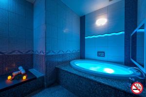 - une salle de bains bleue pourvue d'une baignoire avec une voiture jouets dans l'établissement HOTEL Dior7, à Hamamatsu