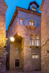 an old stone building with a light shining on it at Berislavic Palace in Trogir