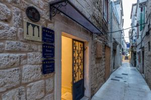 an alley with a door in a brick building at Berislavic Palace in Trogir