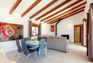 sala de estar con mesa, sillas y sofá en Villa Molinas, en Pollensa