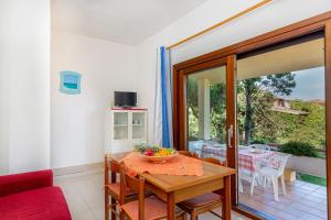 a dining room with a table and a glass door at Centro Residenziale Le Canne in San Teodoro