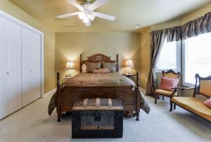 LampeFAMILY REUNIONS Breathaking Lakefront Private Resort FREE DOCK CANOE KAYAK的一间卧室配有一张床、一把椅子和吊扇