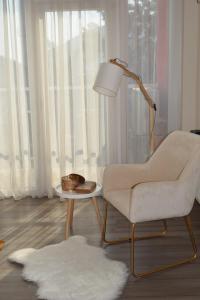 a living room with a chair and a lamp at Sweet Residence Apartment in Arad