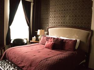 um quarto com uma cama com um cobertor vermelho e uma janela em Cumberland Inn and Spa em Cumberland