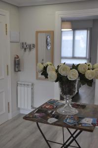 ログローニョにあるApartamento La Estambrera IV con Wifi y Aire Acondicionadoの部屋のテーブルに飾られたバラの花瓶