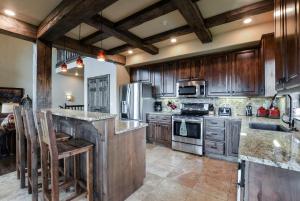 a large kitchen with wooden cabinets and stainless steel appliances at Luxury Lakefront Villa 2Mi to Silver Dollar City POOL Theatre Room Kayaks in Branson