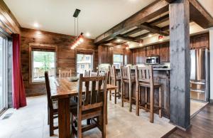 cocina con paredes de madera, mesa de madera y sillas en Luxury Lakefront Villa HUGE POOL Kayaks 2Mi to Silver Dollar City, en Branson