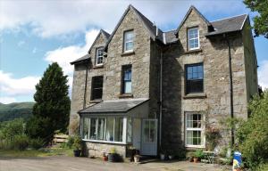 una antigua casa de piedra con ventana en Suie Hunting Lodge en Killin