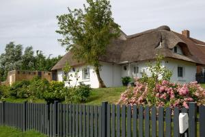 佩爾沃姆的住宿－Dat Slott，白色的房子,有茅草屋顶和栅栏
