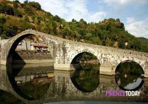 un puente sobre un río con un tren en él en Appartamento Gaylen, en Borgo a Mozzano