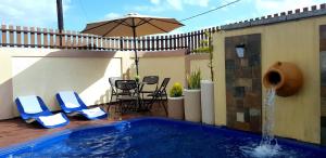 a swimming pool with two chairs and an umbrella at Mont Oreb Villas Ruby, Nothern coast Mauritius in Pereybere