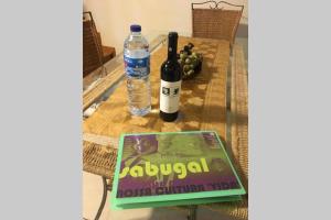 a bottle of wine and a book on a table at A Casinha rústica com todo o conforto in Aldeia da Ponte