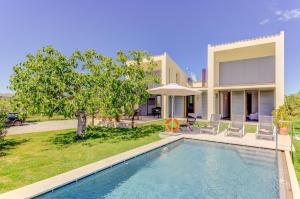 a villa with a swimming pool in front of a house at Villa Vertent by Sealand Villas in Alcudia