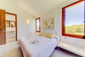a white bedroom with a bed and a window at Villa Vertent by Sealand Villas in Alcudia +16 photos