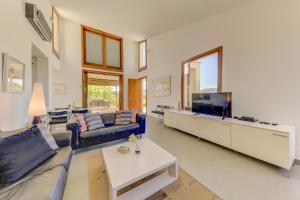 a living room with a couch and a tv at Villa Vertent by Sealand Villas in Alcudia