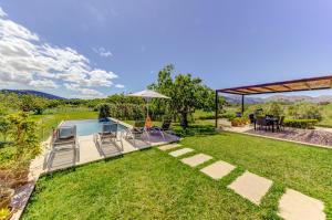 a backyard with a pool and a table and chairs at Villa Vertent by Sealand Villas in Alcudia