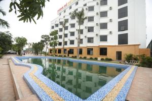 a swimming pool in front of a building at Thông Đỏ Hotel in Vinh