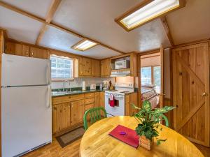 a kitchen with a table and a white refrigerator at Maggie Valley Cabin Rentals in Maggie Valley