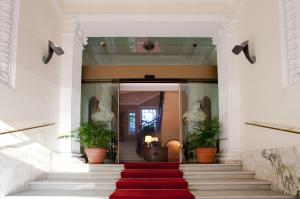 eine rote Treppe mit Teppichboden in einem Gebäude mit Pflanzen in der Unterkunft Aldrovandi Residence City Suites in Rom