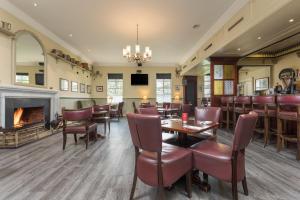 a restaurant with tables and chairs and a fireplace at Park Inn by Radisson Shannon Airport in Shannon