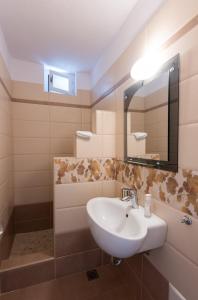 een badkamer met een wastafel en een spiegel bij Efthymia Suites in Faros