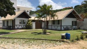 uma casa com uma palmeira no quintal em Baleia Branca Chalé em Porto Belo