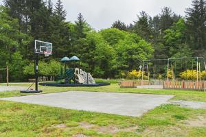 un parque infantil con un aro de baloncesto en Long Beach Camping Resort Studio Cabin 3, en Seaview