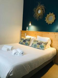 a bedroom with a bed with two towels on it at Hôtel Café Miramar in Le Grau-du-Roi