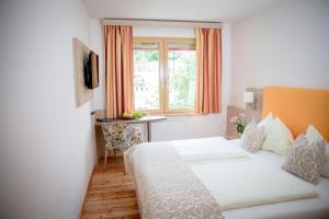 a hotel room with two beds and a window at Hotel Restaurant Thadeushof in Techelsberg am Worthersee