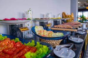 a buffet line with plates of food on display at Fivitel Hoi An Hotel in Hoi An