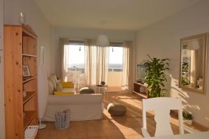 sala de estar con sofá blanco y ventana en Holiday House Aguacate 1 en San Sebastián de la Gomera