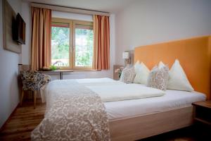 sypialnia z dużym białym łóżkiem i oknem w obiekcie Hotel Restaurant Thadeushof w mieście Techelsberg am Worthersee