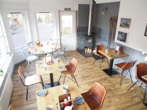 a restaurant with tables and chairs and a fireplace at Ravenscraig Guest House in Aviemore